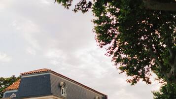 A hotel with a balcony, a sign indicating it is a hotel, and a view of the sky.