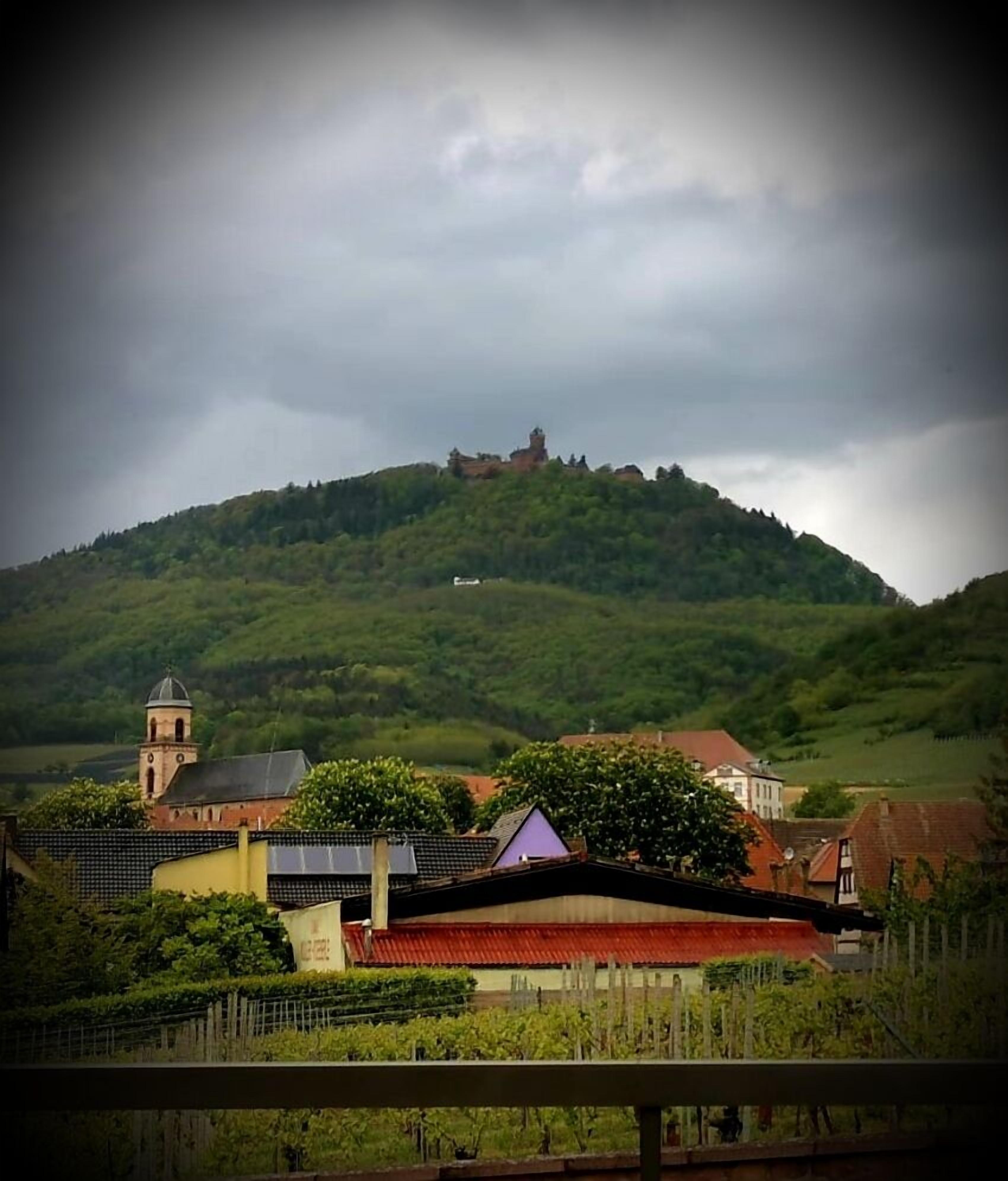 Paisaje rural con una colina, una iglesia y edificaciones residenciales.