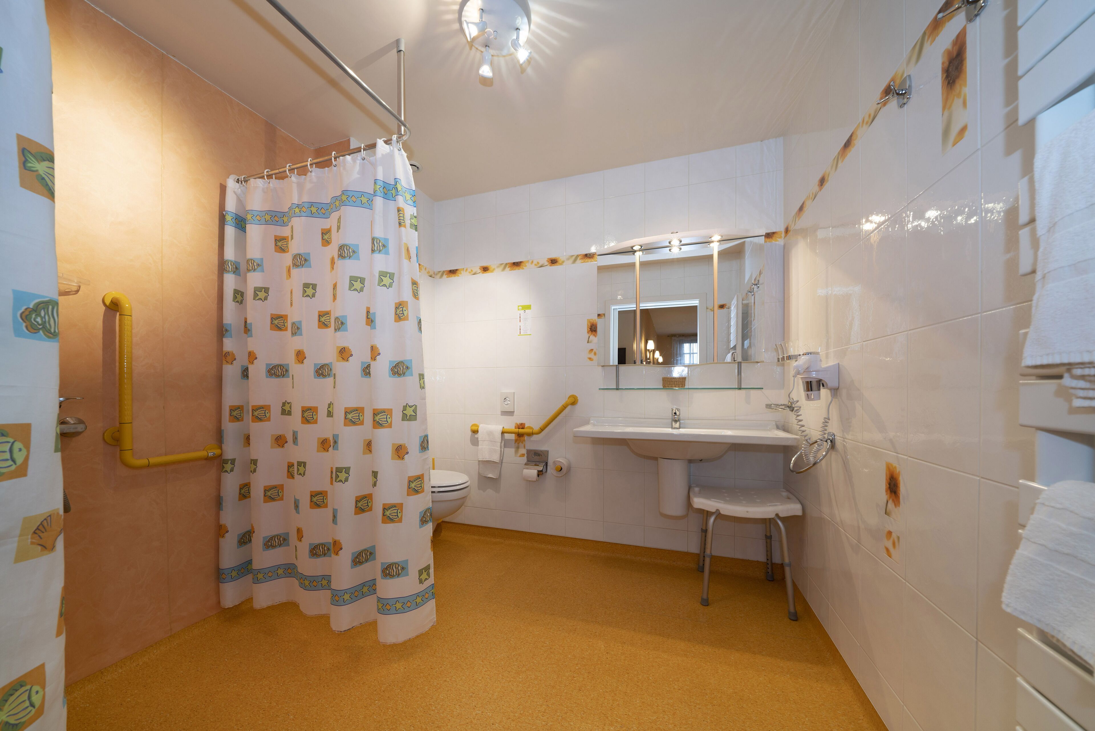 Ein Badezimmer mit Dusche, Toilette, Waschbecken und Spiegel.