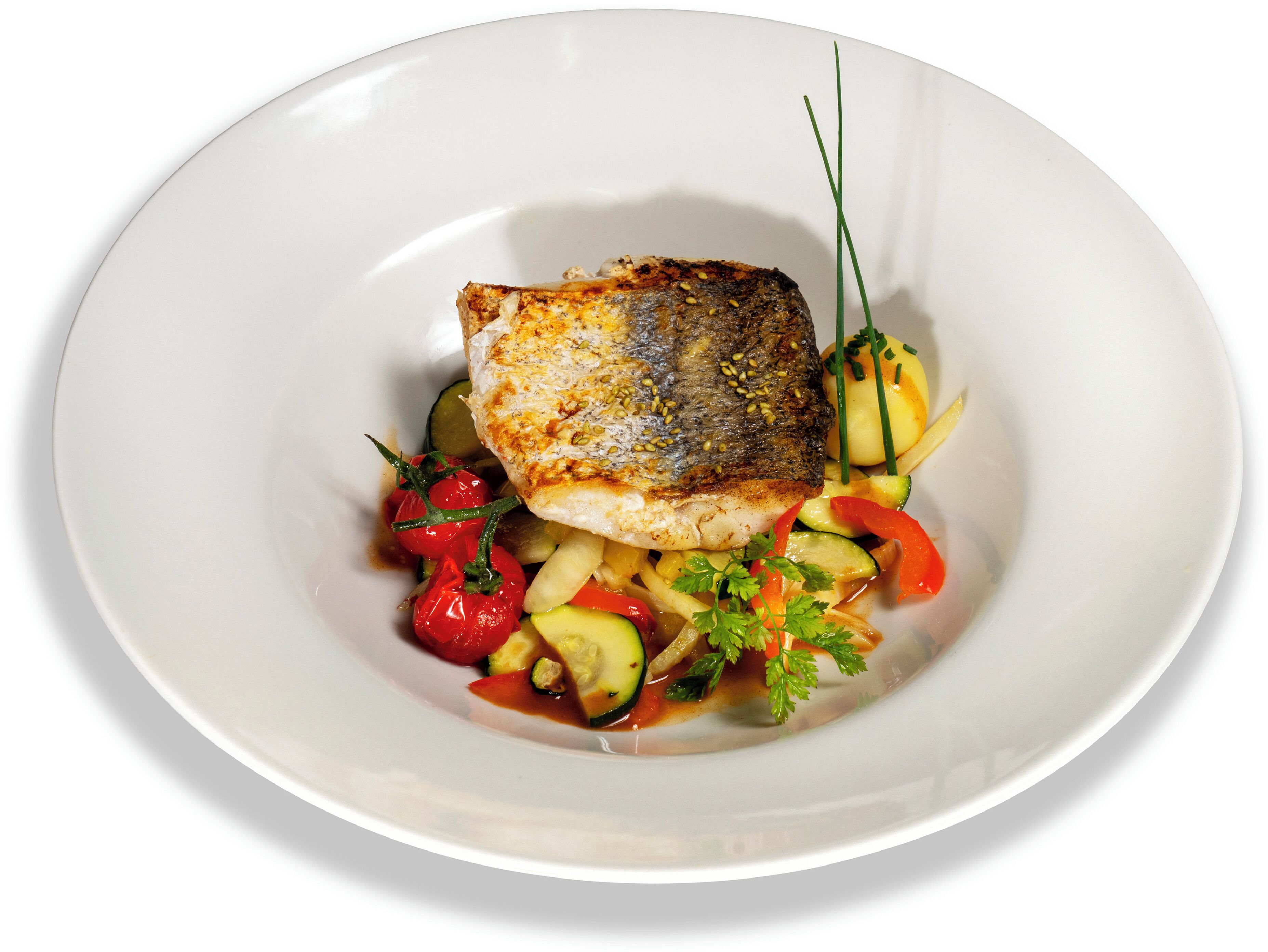 A white plate with a piece of grilled fish, cherry tomatoes, zucchini, and a garnish of parsley.