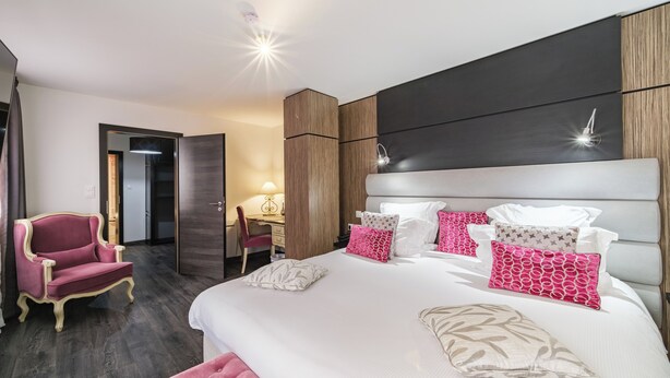 A modern hotel room with a large bed, a desk, and a chair. - Hostellerie du Château (Eguisheim)