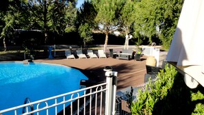 A swimming pool surrounded by lounge chairs and a fence. - Les Charmilles (Lux)