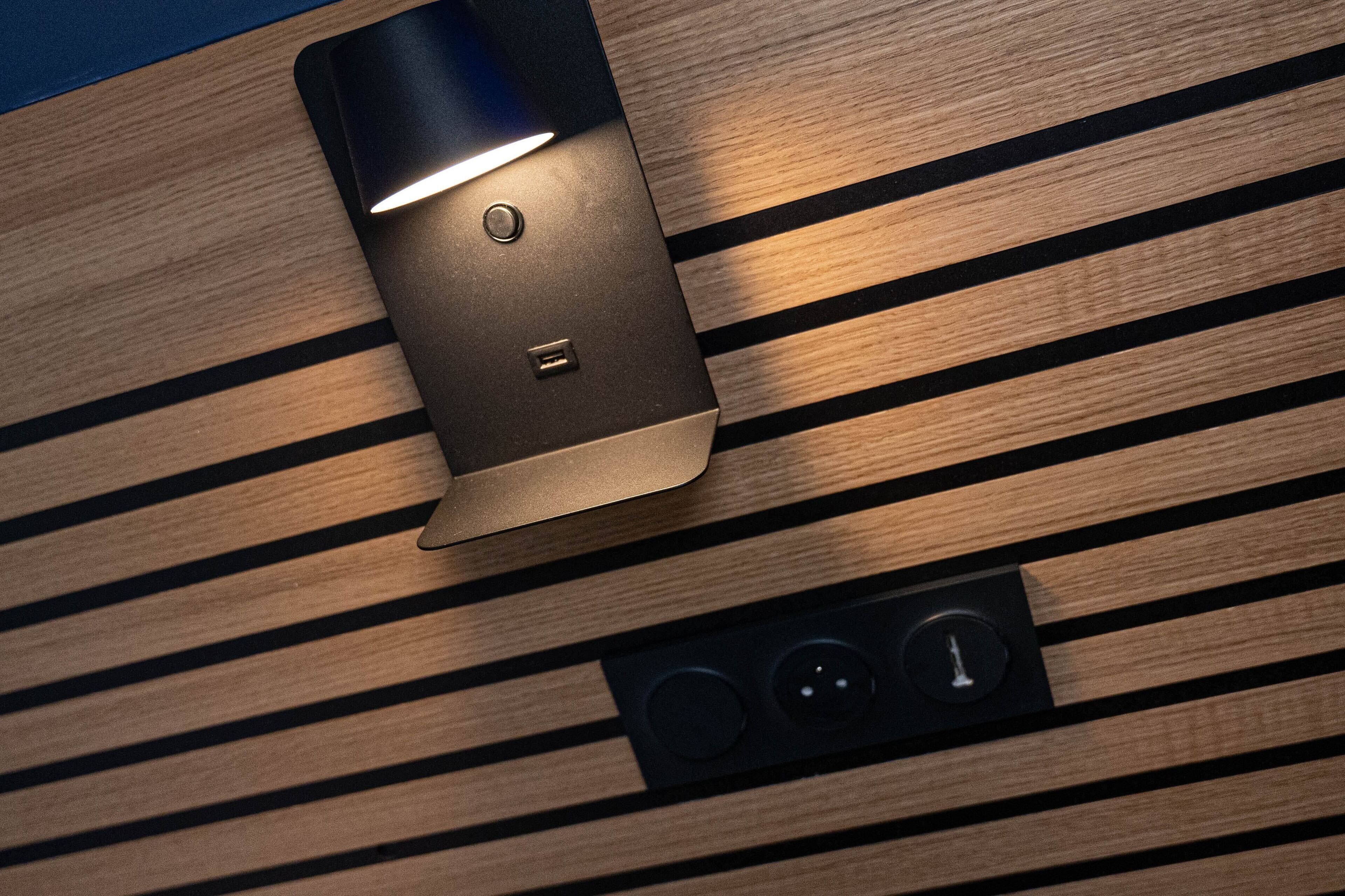 A modern, sleek light fixture with a metallic finish and a small control panel below it.
