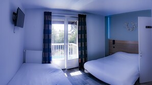 A hotel room with two beds, a TV, a sliding glass door to a balcony, and a wall-mounted light fixture. - Les Charmilles (Lux)