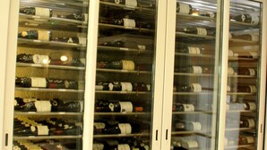 A wine cellar with glass doors and a sign above reading "Cave Des Grands Crus". - Les Charmilles (Lux)