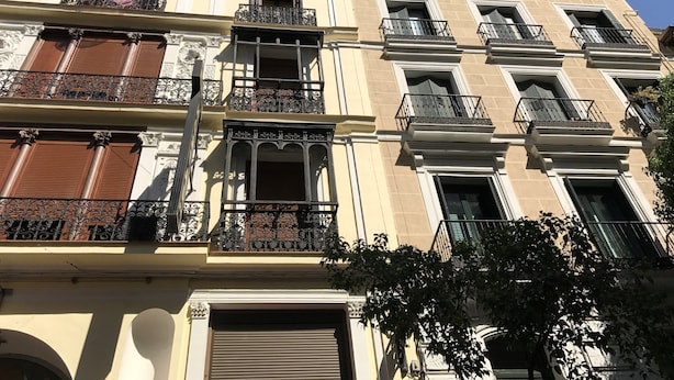 A multi-story building with ornate balconies, large windows, and a traditional architectural style. - Hostal El Pilar (Madrid)
