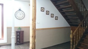 A staircase with wooden railings, a wall clock, and framed pictures. - Hostal El Pilar (Madrid)