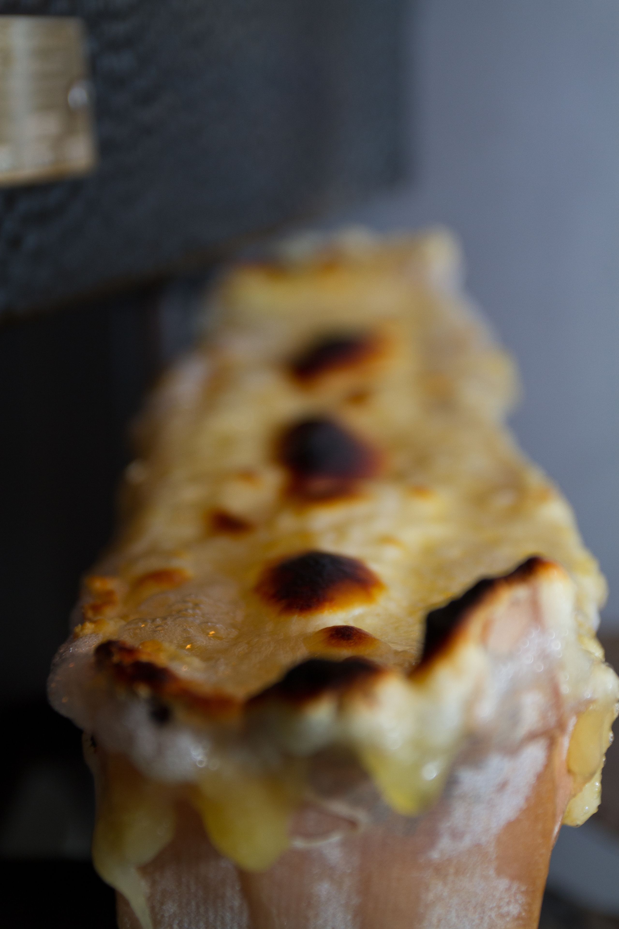 Gros plan sur un plat dont le fromage est fondu et dont la surface est croustillante.