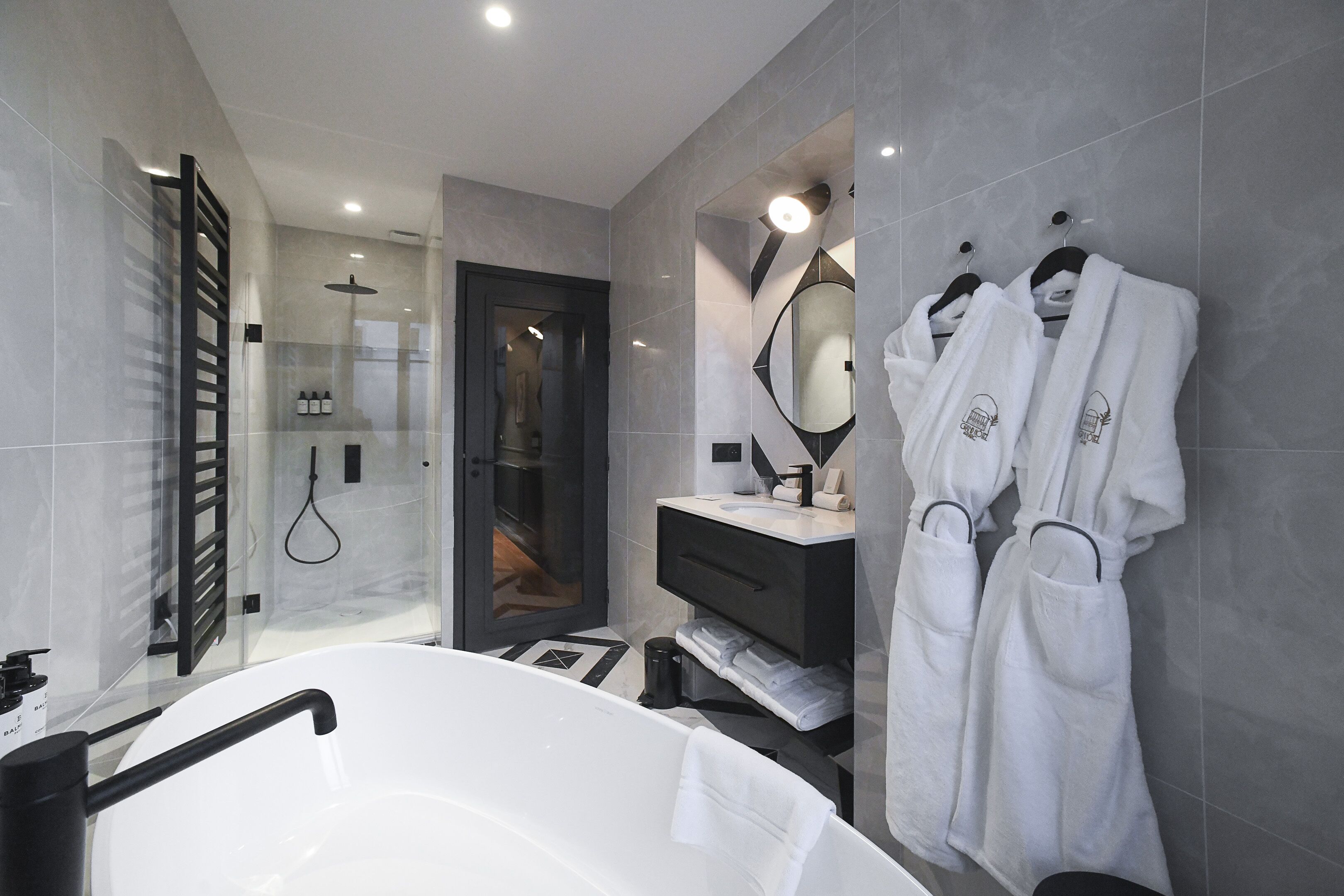 A modern bathroom with a large bathtub, a glass shower enclosure, and a vanity with a mirror.