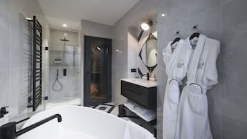 A modern bathroom with a large bathtub, a glass shower enclosure, and a vanity with a mirror.