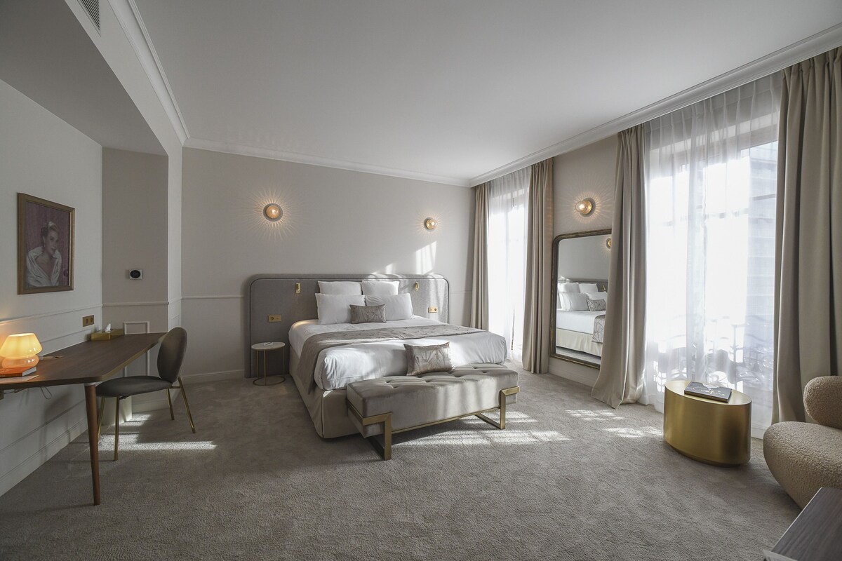 Een moderne hotelkamer met een groot bed, een bureau en een zithoek.