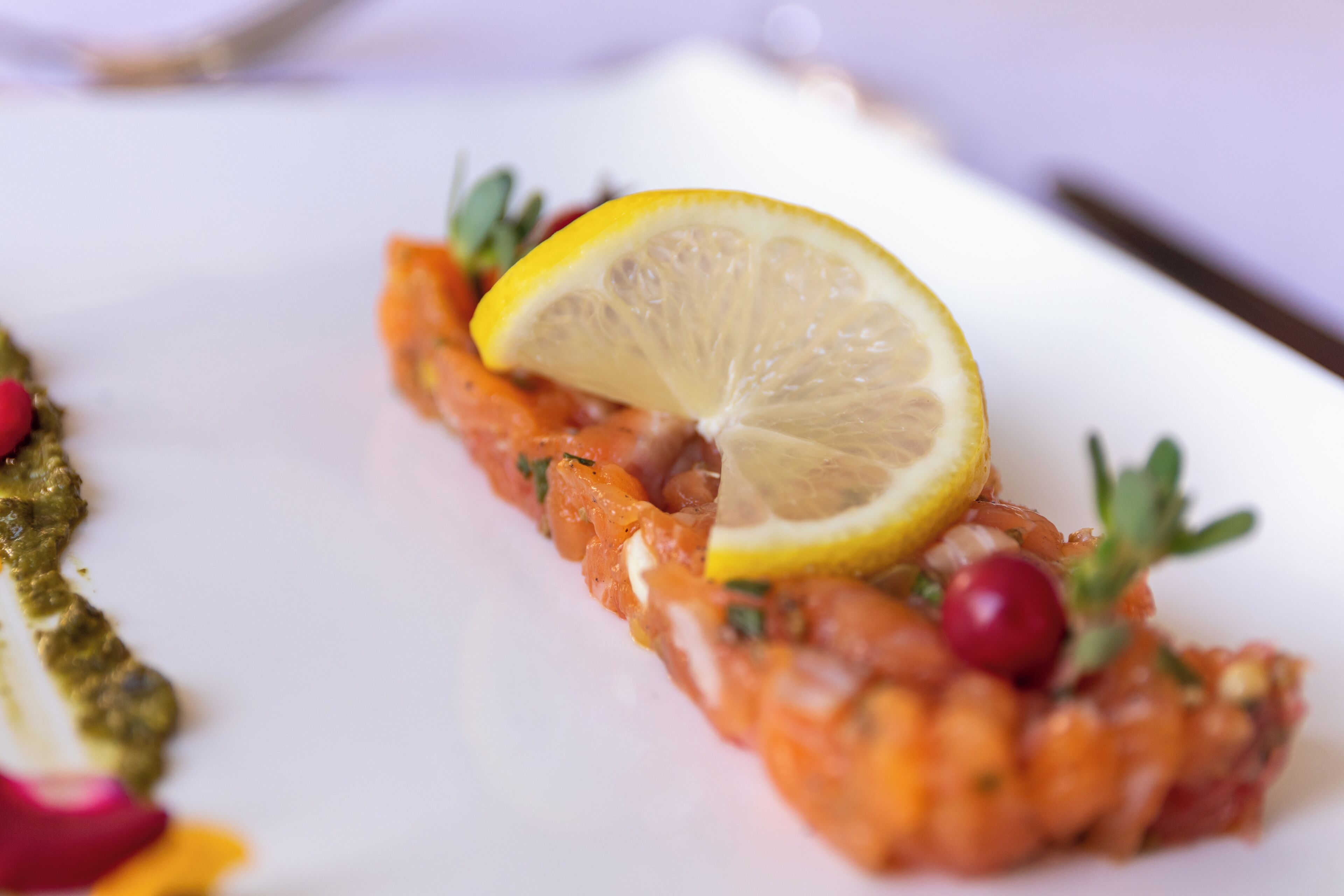 A dish with salmon, lemon, and herbs.