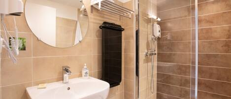 A bathroom with a sink, mirror, towel rack, and shower.