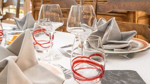Una tavola imbandita con bicchieri da vino, piatti e tovaglioli.