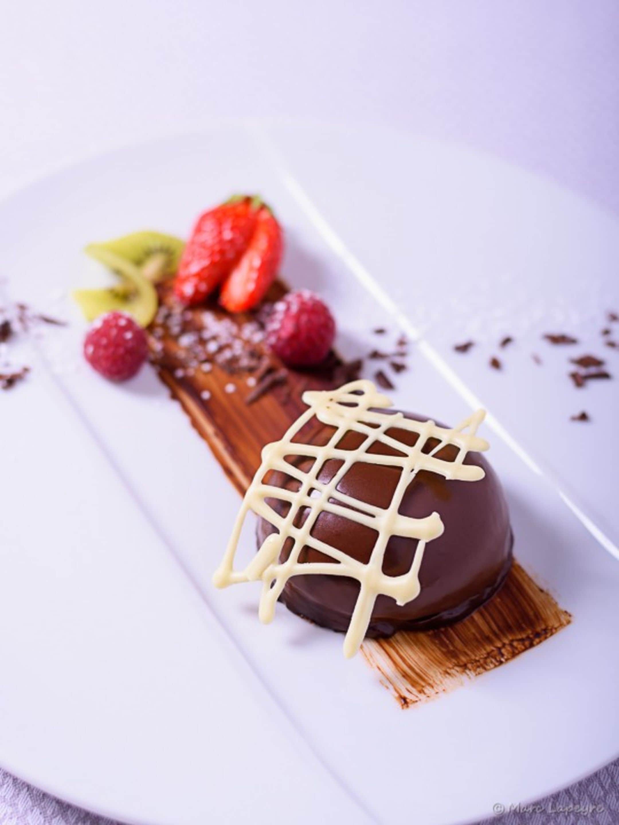 A dessert with chocolate and white icing on a plate.