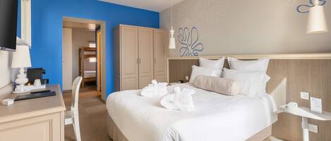 Una habitación de hotel con una cama grande, un escritorio, una silla y un televisor.
