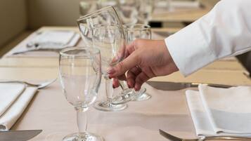A table set with clear wine glasses, a knife, and a spoon.