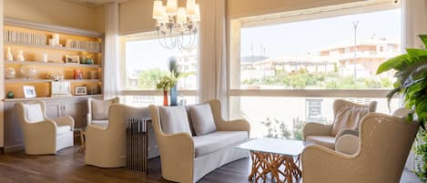 A spacious living area with a sofa, chairs, a coffee table, and a bookshelf.