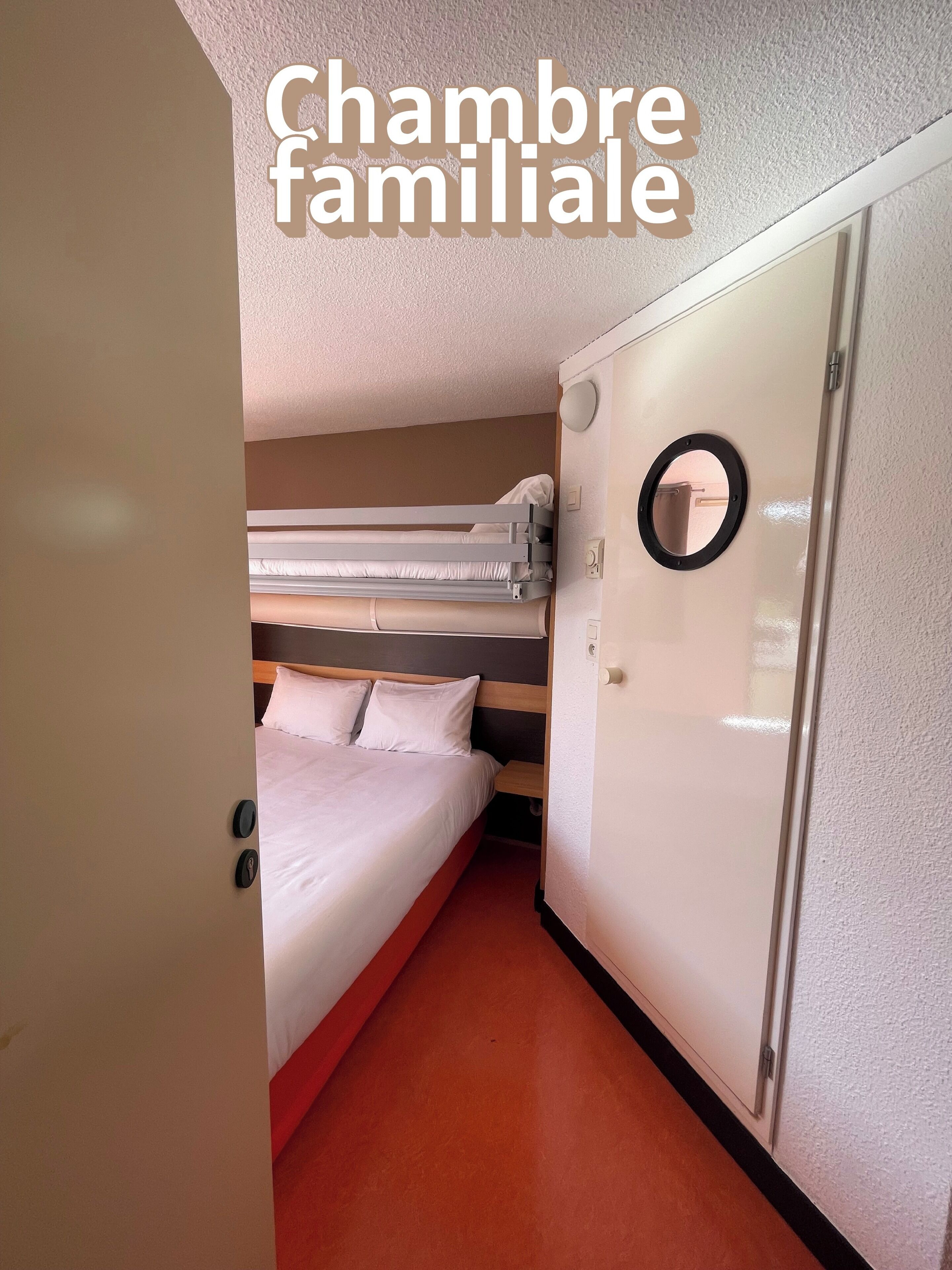 A family room with bunk beds, a wardrobe, and a round mirror.