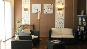 Una sala de estar con dos sofás, una mesita de centro, una lámpara de pie y una estantería.