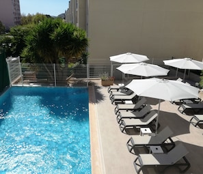 Seasonal outdoor pool, open 9:00 AM to 8:00 PM, pool umbrellas