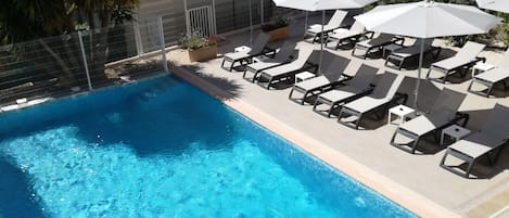 Seasonal outdoor pool, open 9:00 AM to 8:00 PM, pool umbrellas