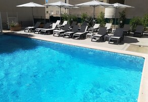 Seasonal outdoor pool, open 9:00 AM to 8:00 PM, pool umbrellas
