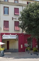 Un hotel con un cartel que dice "HOTEL TOPPIN" y un letrero de estacionamiento.