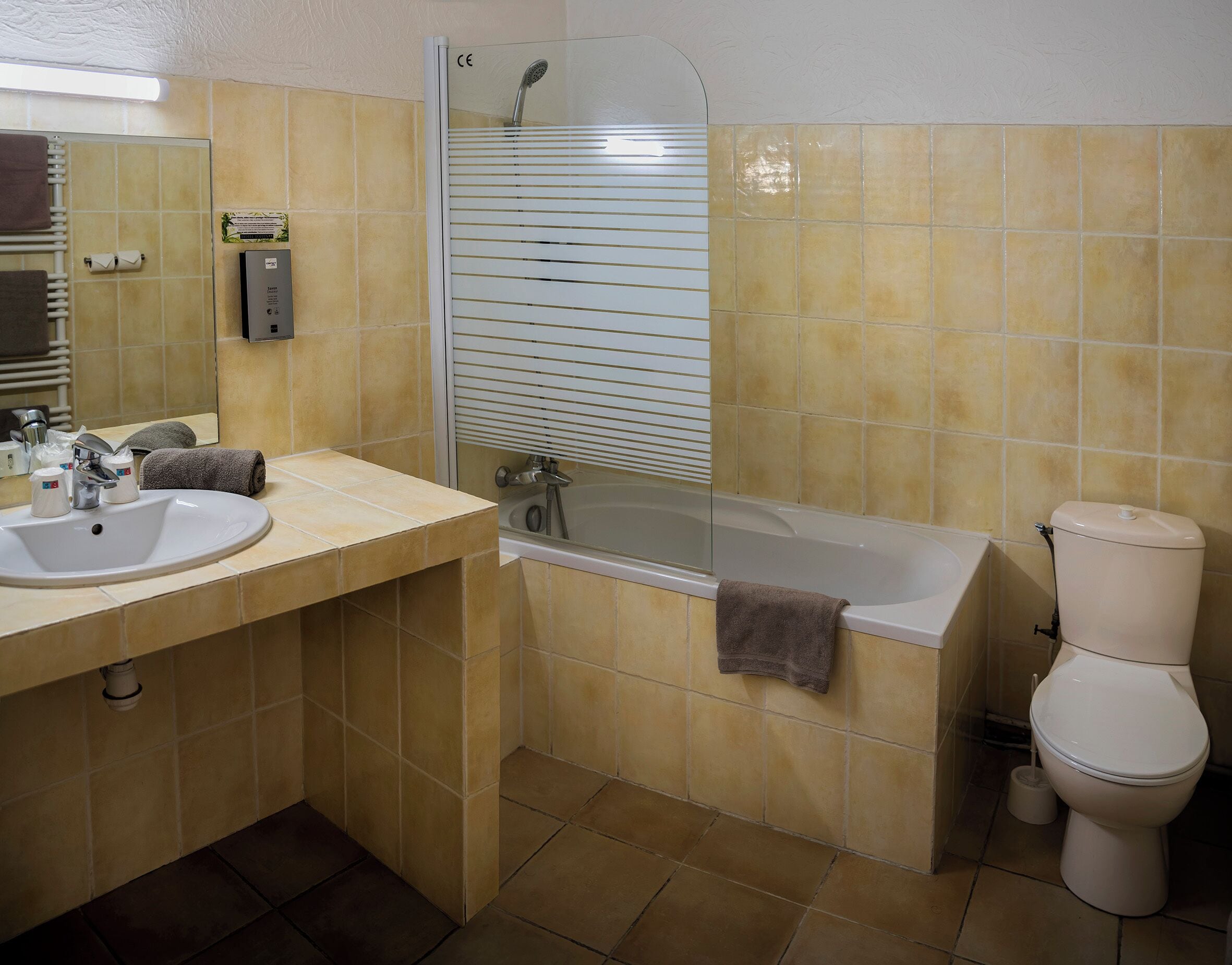Ein Badezimmer mit Waschbecken, Spiegel, Toilette und Badewanne.