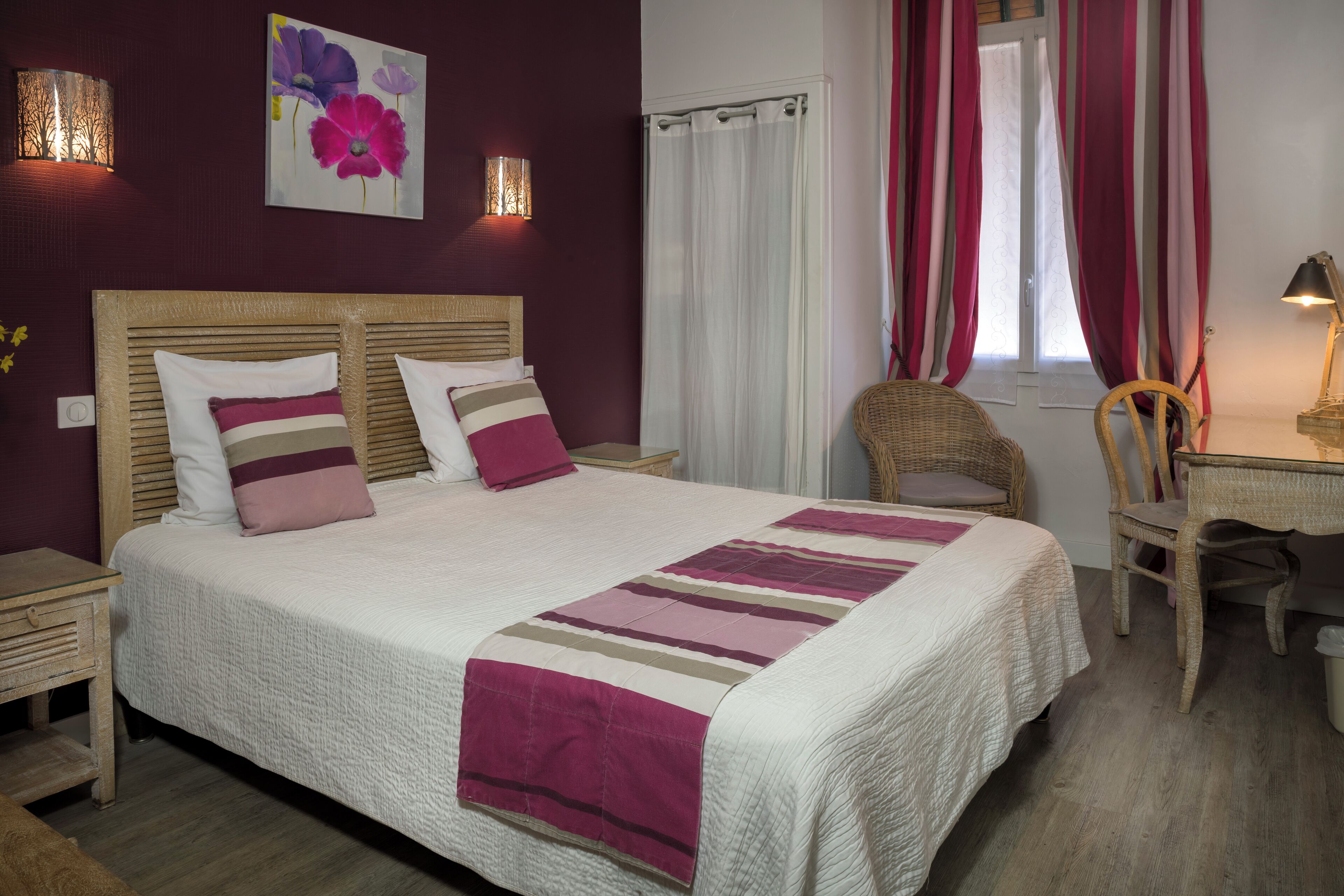 A neatly made bed with a striped blanket, a wooden headboard, and two bedside tables.