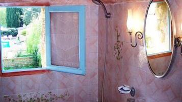 Une salle de bain avec un lavabo, un miroir et une douche.