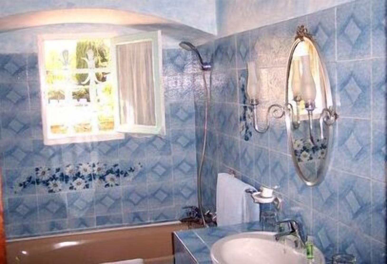 A bathroom with a shower, a sink, and a mirror.