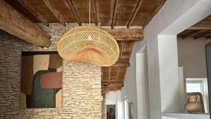A hallway with stone walls, a wooden ceiling, and a hanging woven light fixture. - Le Mas de Garrigon - Boutique Hôtel & Spa (Roussillon)