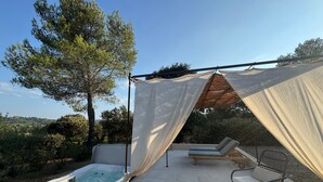 A hot tub area with a canopy, lounge chairs, and a tree in the background. - Le Mas de Garrigon - Boutique Hôtel & Spa (Roussillon)