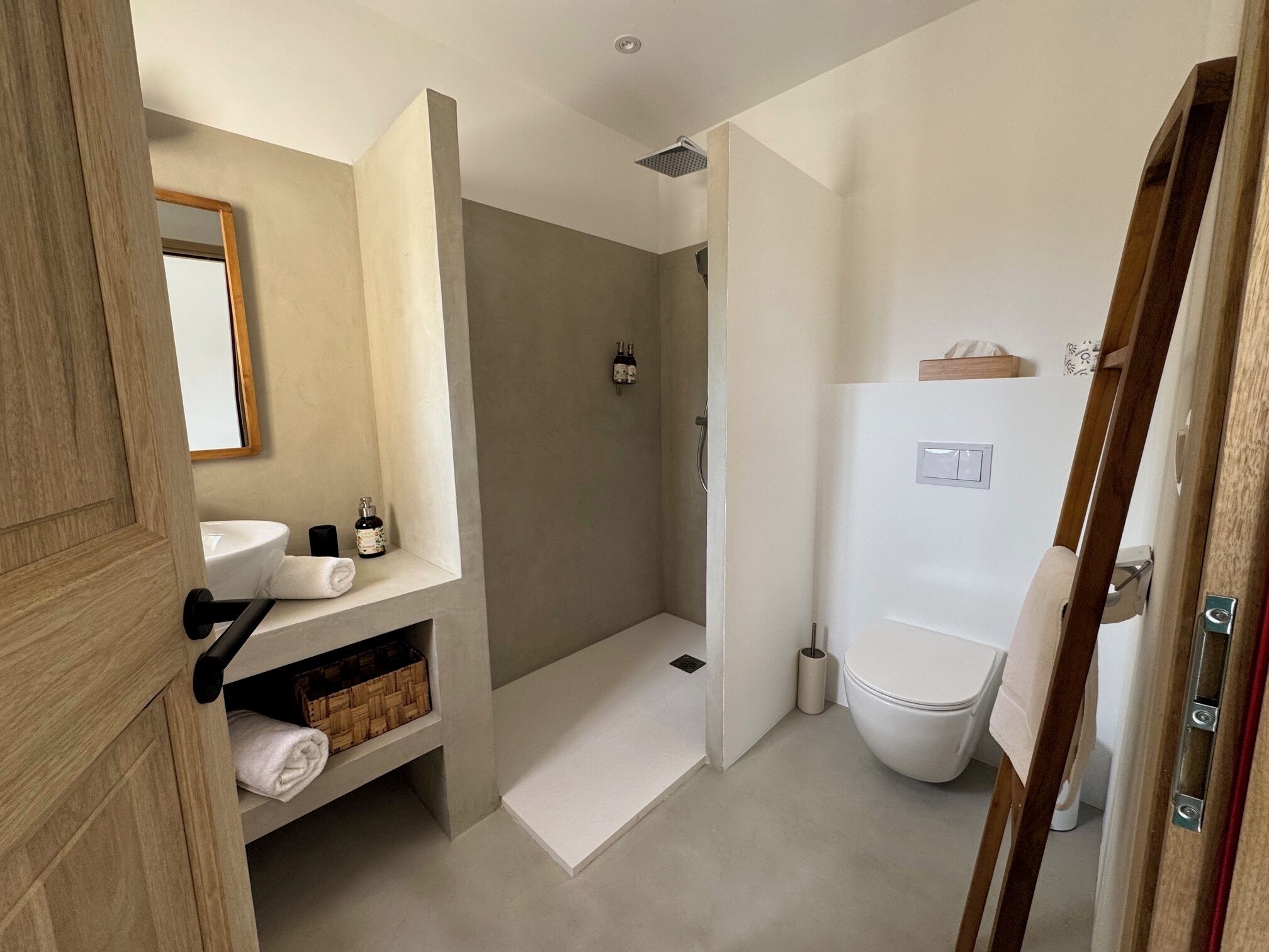 A modern bathroom with a shower, toilet, and sink.