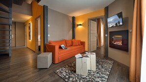 Una sala de estar moderna con un sofá, una mesa de centro y un televisor montado en la pared.