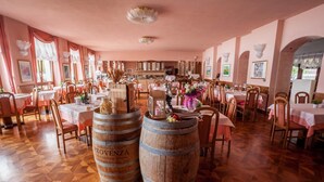 A restaurant with wooden barrels, tables, chairs, and a warm interior.