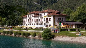 A hotel with a restaurant and outdoor seating by a lake.