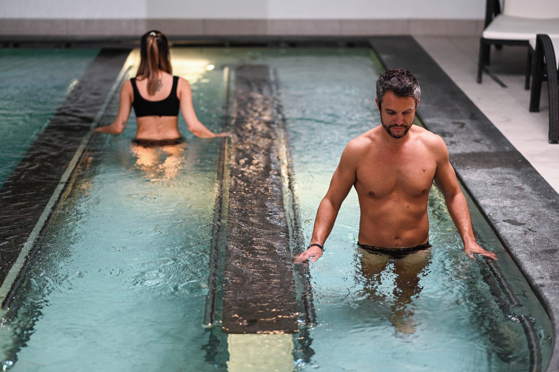 A swimming pool with two people in the water.