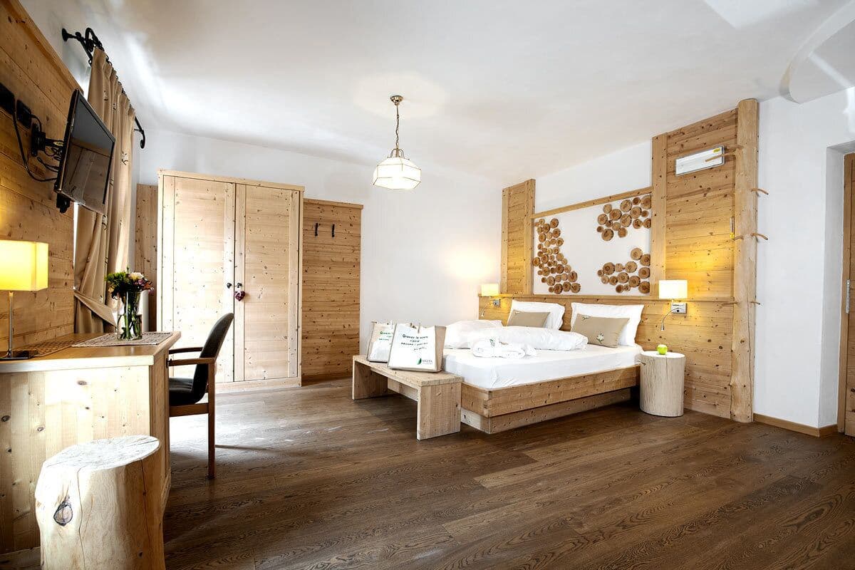 Une chambre à coucher décorée dans un style rustique, avec un lit, une table de chevet, une chaise et un bureau équipé d’une lampe.