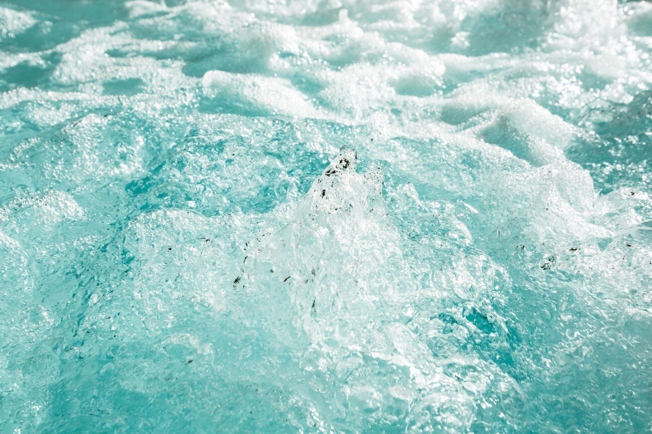 Primer plano de una superficie de agua con ondulaciones y salpicaduras visibles.