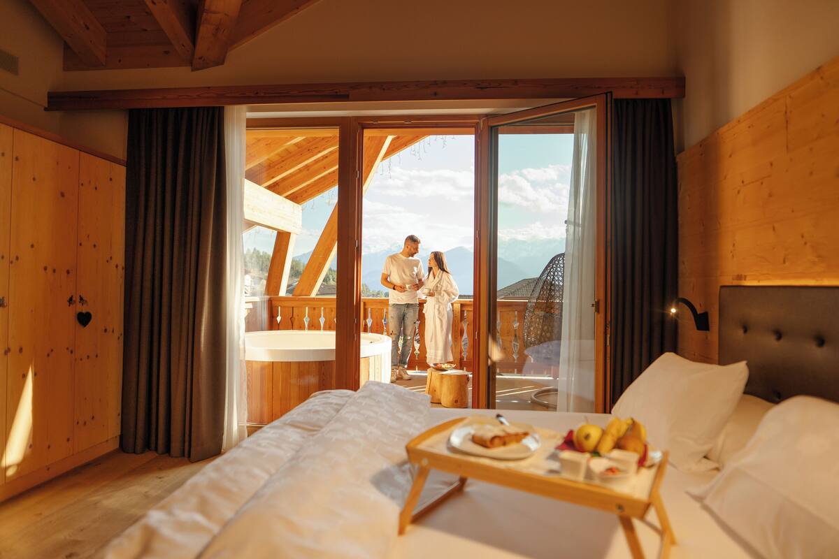 Une chambre à coucher avec un grand lit, une tête de lit en bois et un plateau de petit-déjeuner sur la table de chevet.