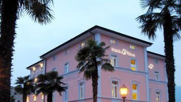 Un edificio rosa con un letrero que dice 'Hotel de la Mer'.