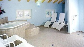 Un cuarto de spa con un jacuzzi, sillones reclinables y piso de baldosas.