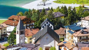 A coastal town with a prominent church, residential buildings, and a beach. - Olisamir (Cavedago)