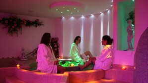 A spa area with tiled seating and a central water feature. - Olisamir (Cavedago)