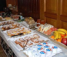 Un tavolo del buffet con diversi cibi, tra cui pasticceria, frutta e latticini.
