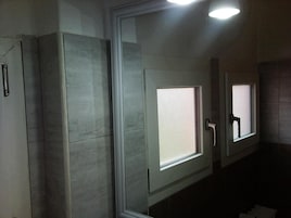 Un baño con tres puertas, cada una con un ventanal de cristal esmerilado y un picaporte.