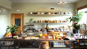 Um buffet de café da manhã com diversos alimentos, uma máquina de café e uma seleção de bules em prateleiras.