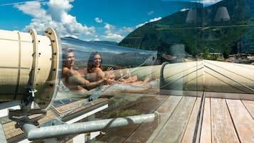 A transparent glass floor in a room with a view of a mountainous landscape.
